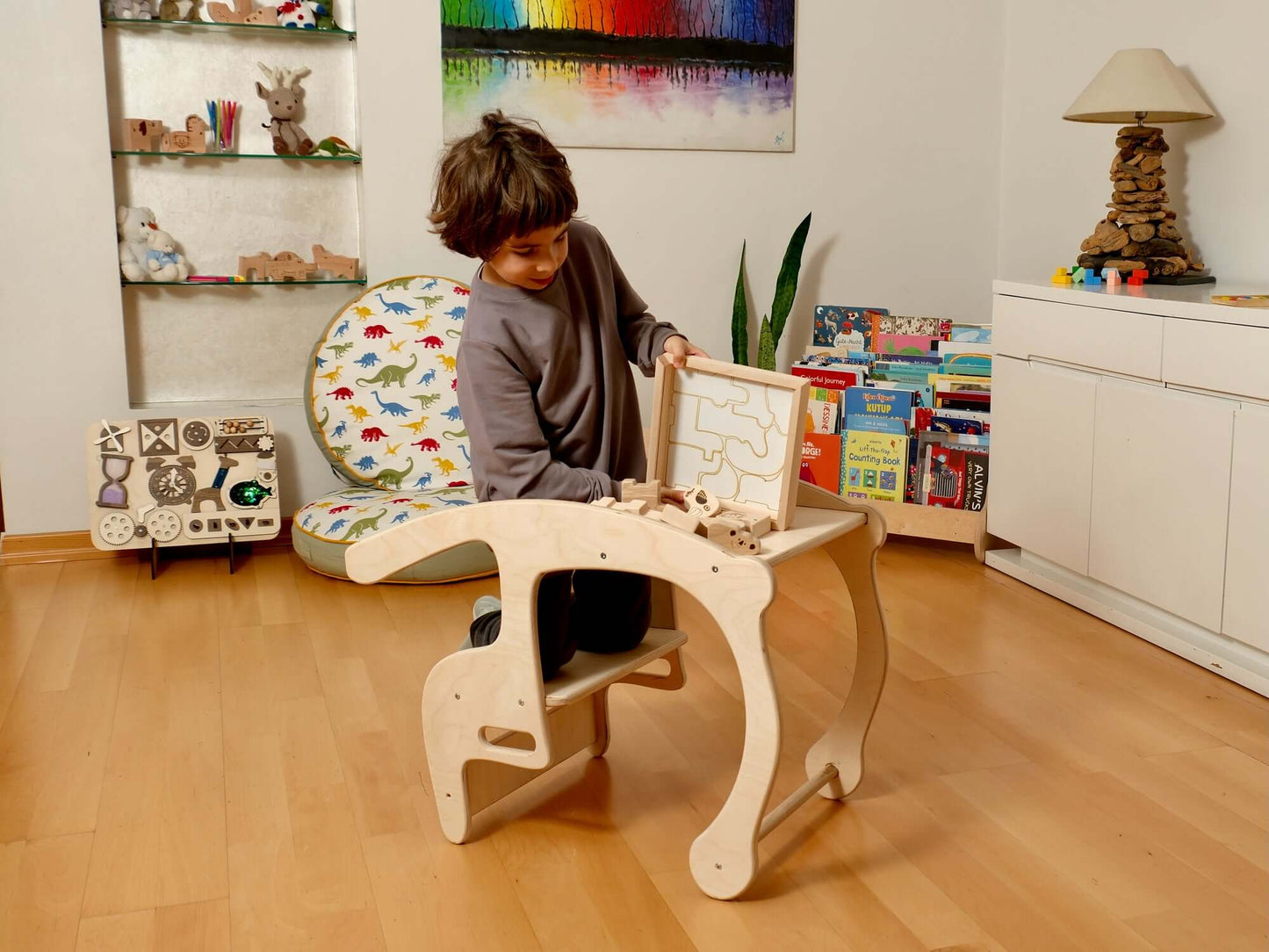 Toddler engaged with a wooden safari animal puzzle box, promoting hands-on learning and fun in a playful indoor environment.